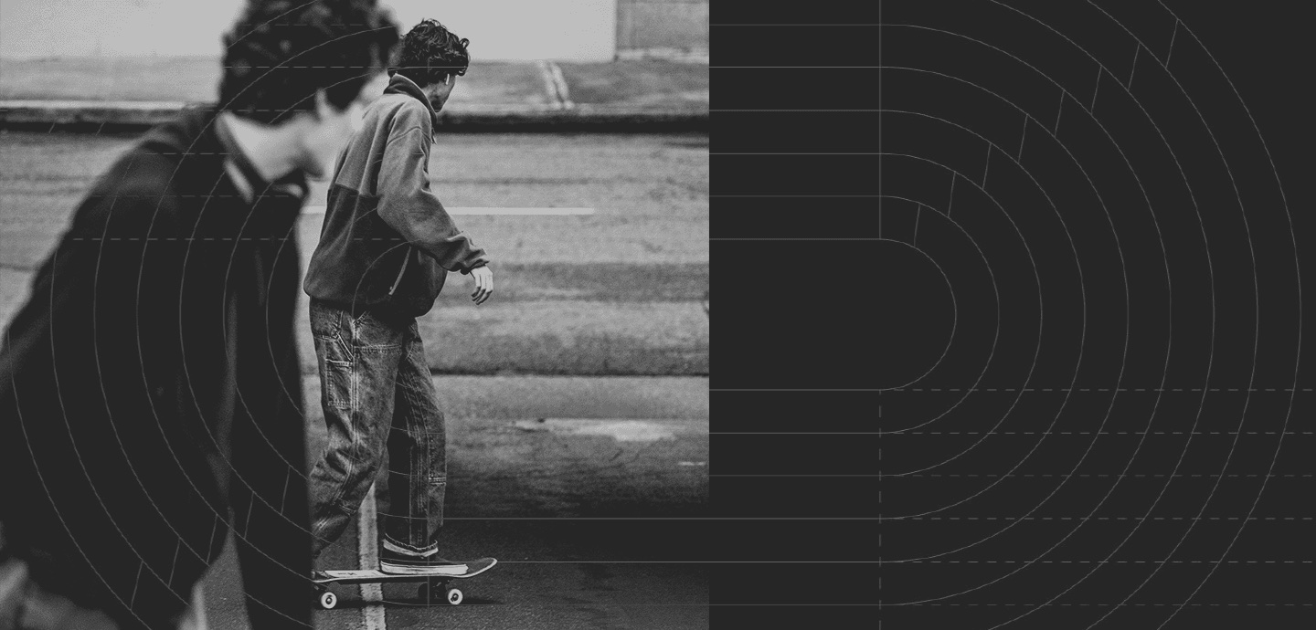 Dois skatistas na rua, fotografados em preto e branco, com um traçado de linhas concêntricas sobreposto.