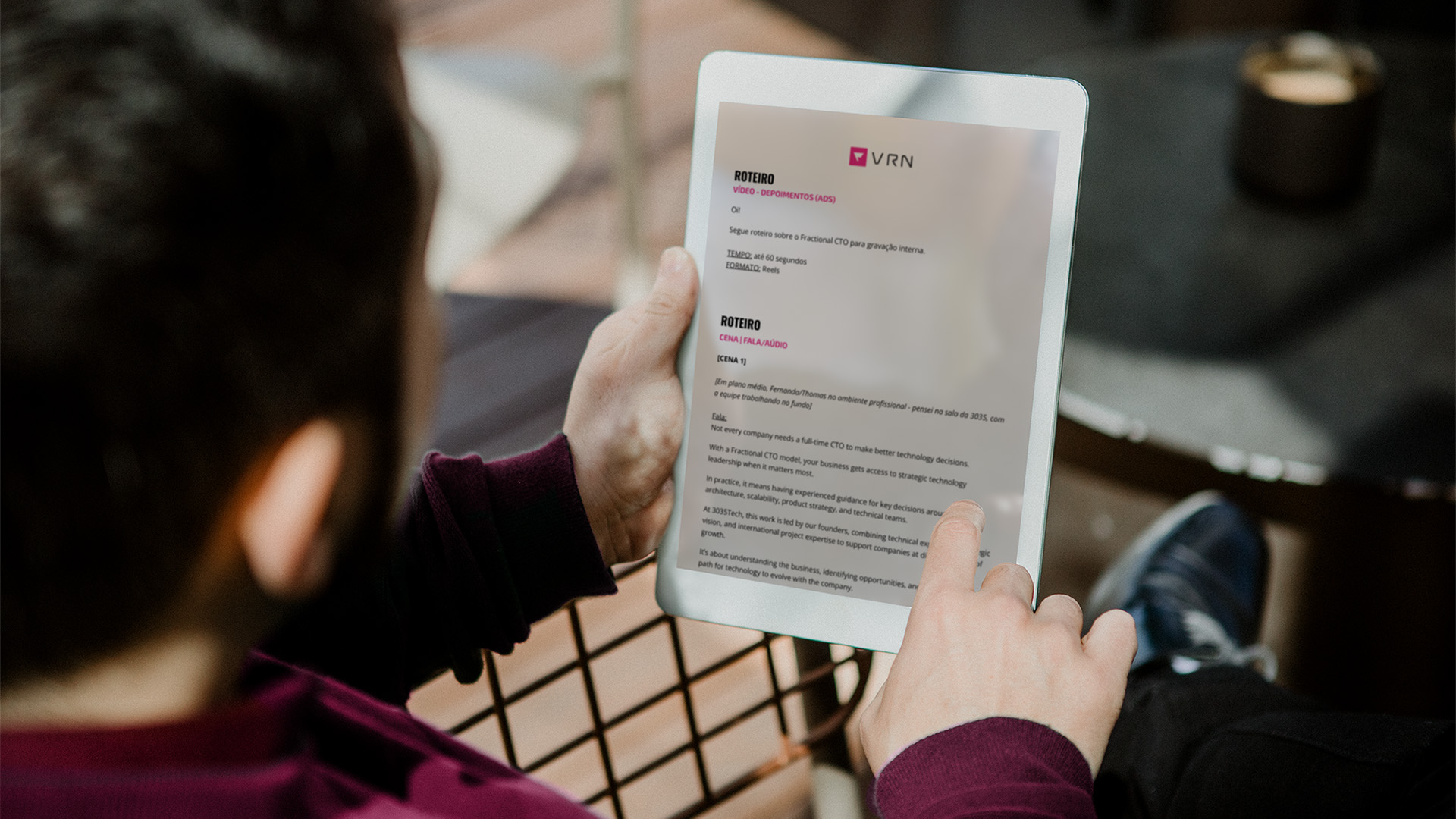 Foto por cima do ombro de quem lê num tablet o roteiro de vídeo da 3035TECH assinado pela Voren: o cabeçalho VRN, o bloco de depoimentos em ADS com tempo e formato, e a cena de fala sobre o modelo de Fractional CTO.