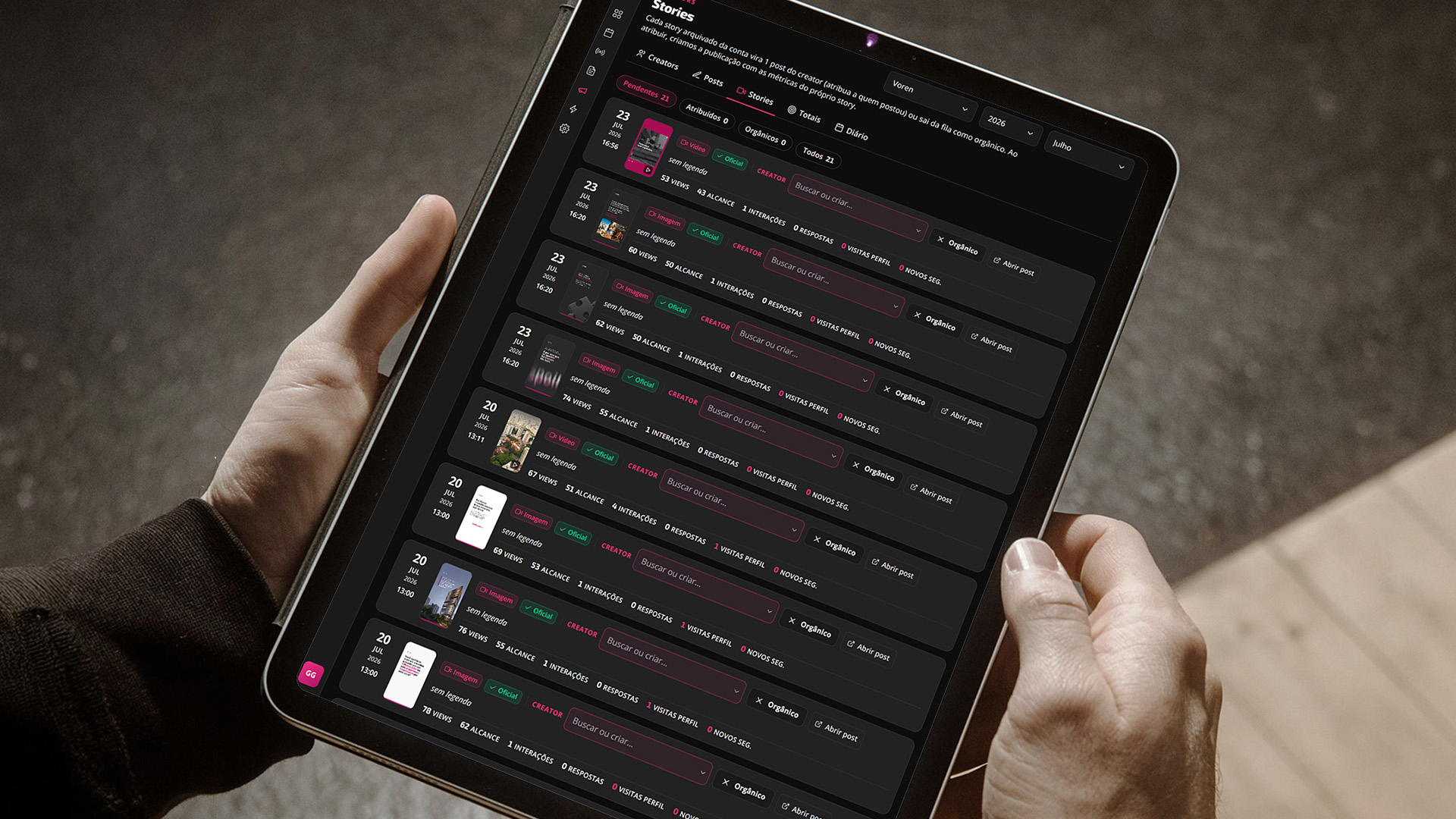 Tablet nas mãos com a aba Stories da plataforma de creators da Voren: cada story arquivado vira uma linha com miniatura, data, views, alcance, interações, respostas e novos seguidores, ao lado do campo que atribui a publicação ao creator.