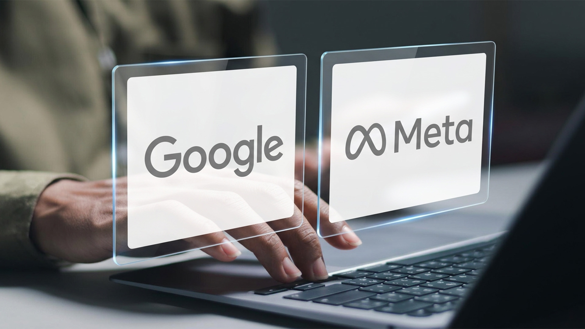 Mão sobre o teclado de um notebook com dois painéis translúcidos flutuando acima das teclas, um com a marca Google e outro com a marca Meta, lado a lado como as duas opções de mídia paga.